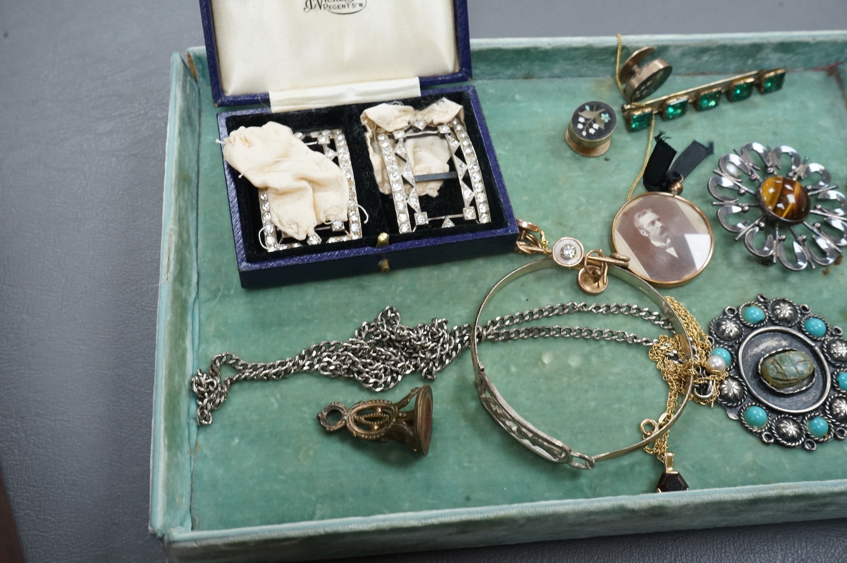 Assorted costume and other jewellery including a cased pair of paste buckles, agate set fob seal, a9ct pendant on a 9ct gold chain, Egyptian white metal bangle, a Scottish silver pendant, etc, housed in a mahogany work b